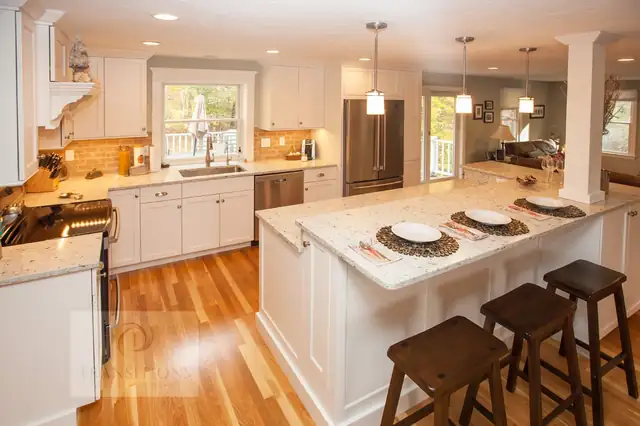Cohasset, MA kitchen with a bi-level island, built-in wine rack and white cabinetry