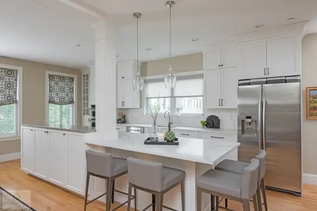 Classic white Scituate, MA kitchen with Mouser cabinetry, Calacatta Rome quartz and a contrasting island