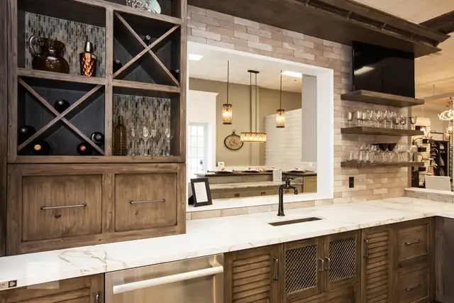 Bar display in the Transitions showroom in Norwell with rustic wood cabinets, wine storage, a marble counter and open shelves