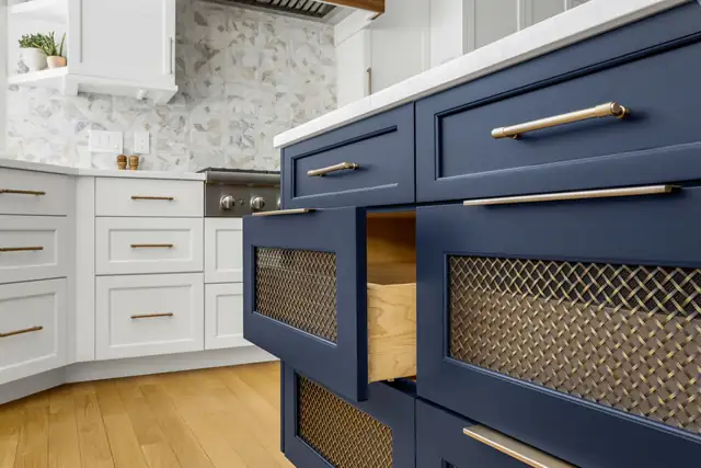 Norwell, MA kitchen detail with navy blue cabinets, gold bar pulls and wire mesh inset panels