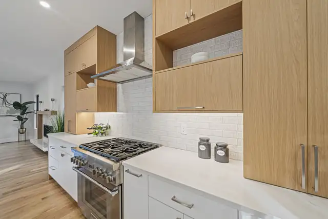 South Shore kitchen remodel with white oak upper cabinets, white lowers, quartz counters and a stainless range