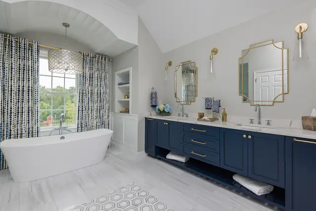 Norwell, MA bathroom remodel with a navy double vanity, freestanding tub and patterned window curtains