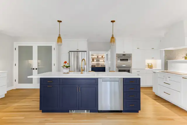 Two-tone Milton, MA kitchen with an Indigo navy Mouser island, white Divinity perimeter cabinets and brass hardware